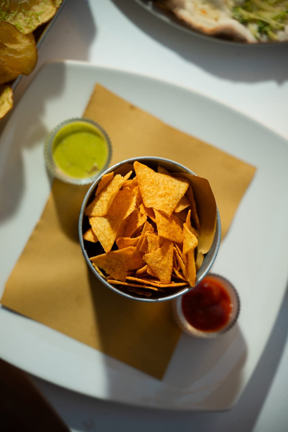 Nachos croccanti con salsa e un drink dell'aperitivo